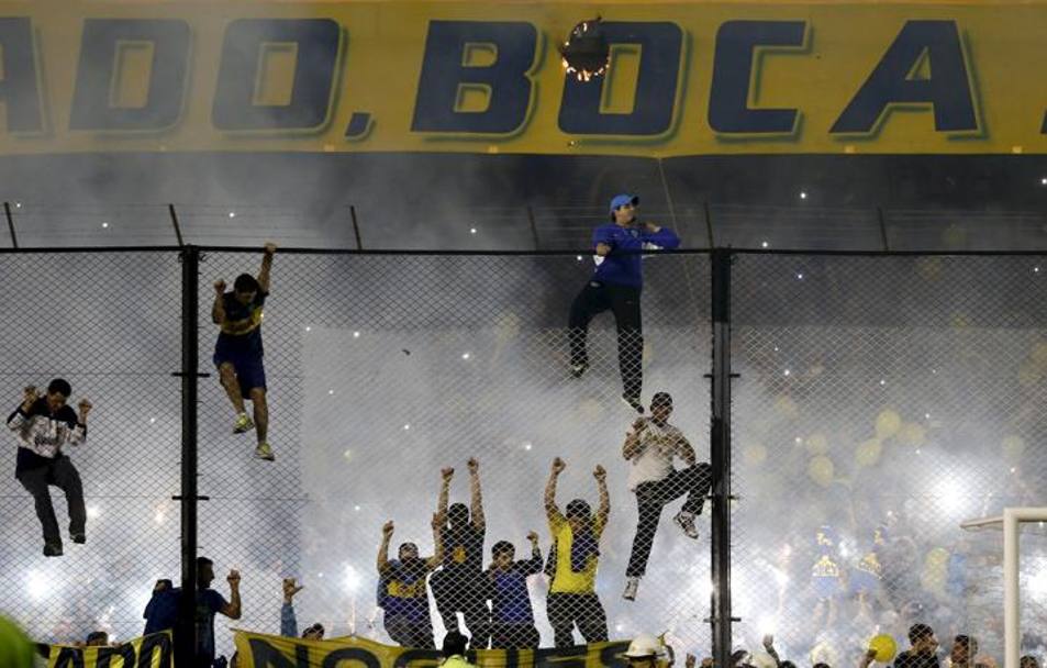 Tifosi del Boca arrampicati sulle recinzioni a bordocampo. Action Images